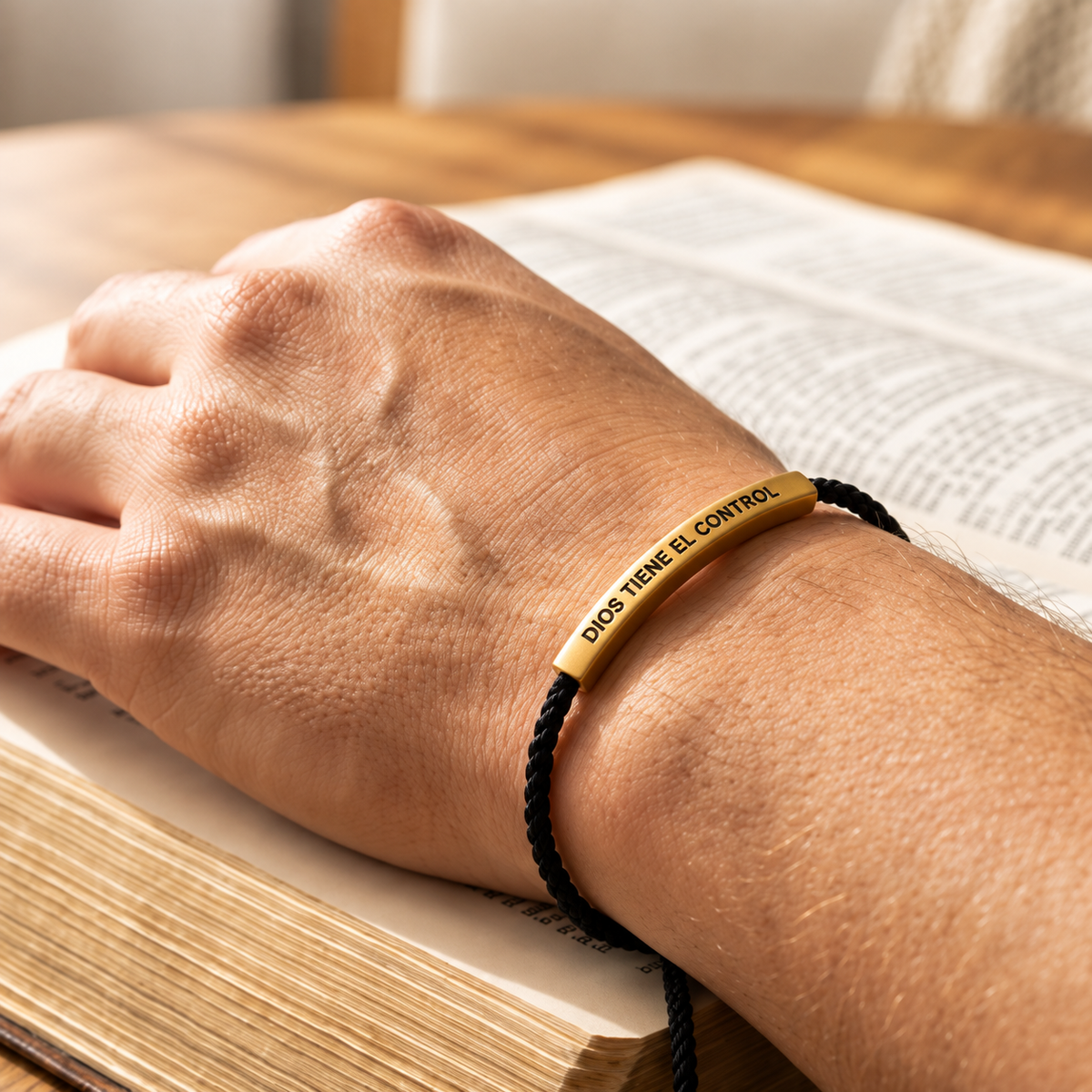 Dios Tiene el Control bracelet worn beside an open book
